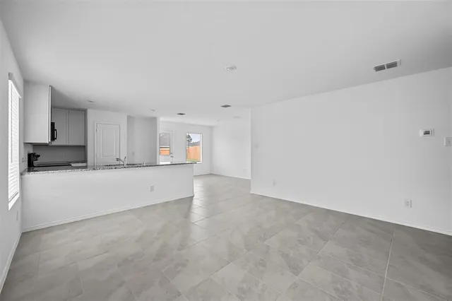 a view of an empty room with kitchen