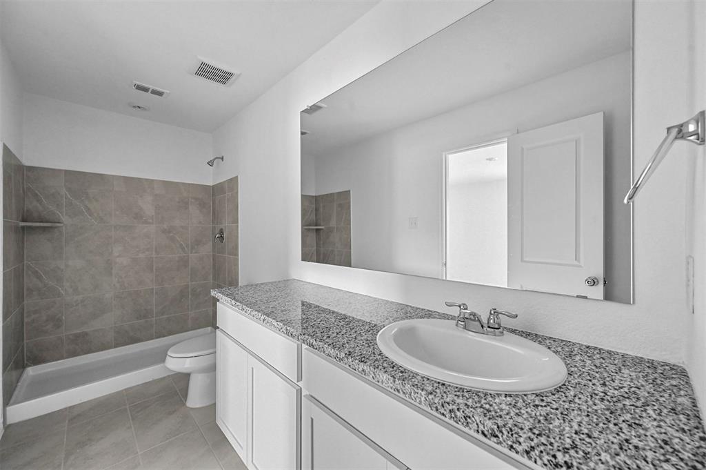 1737 Overall Lane Dallas, TX 75253 - Photo 17 of 21 a bathroom with a granite countertop sink a toilet and shower