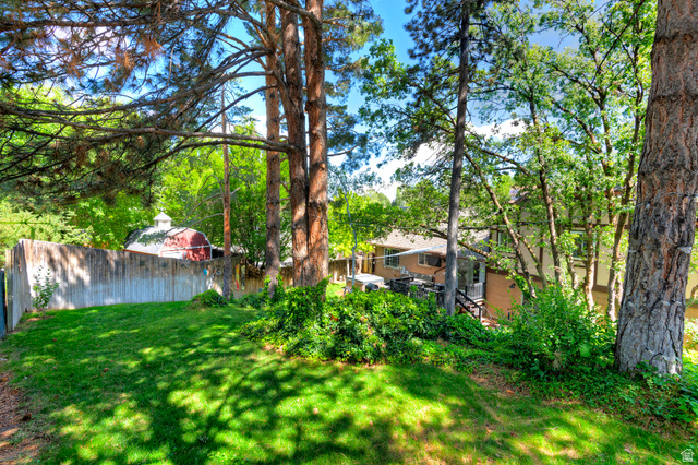 3310 Creek Road Salt Lake City, UT 84121 - Photo 42 of 49 Expansive backyard featuring a lush lawn, mature trees, and a privacy fence