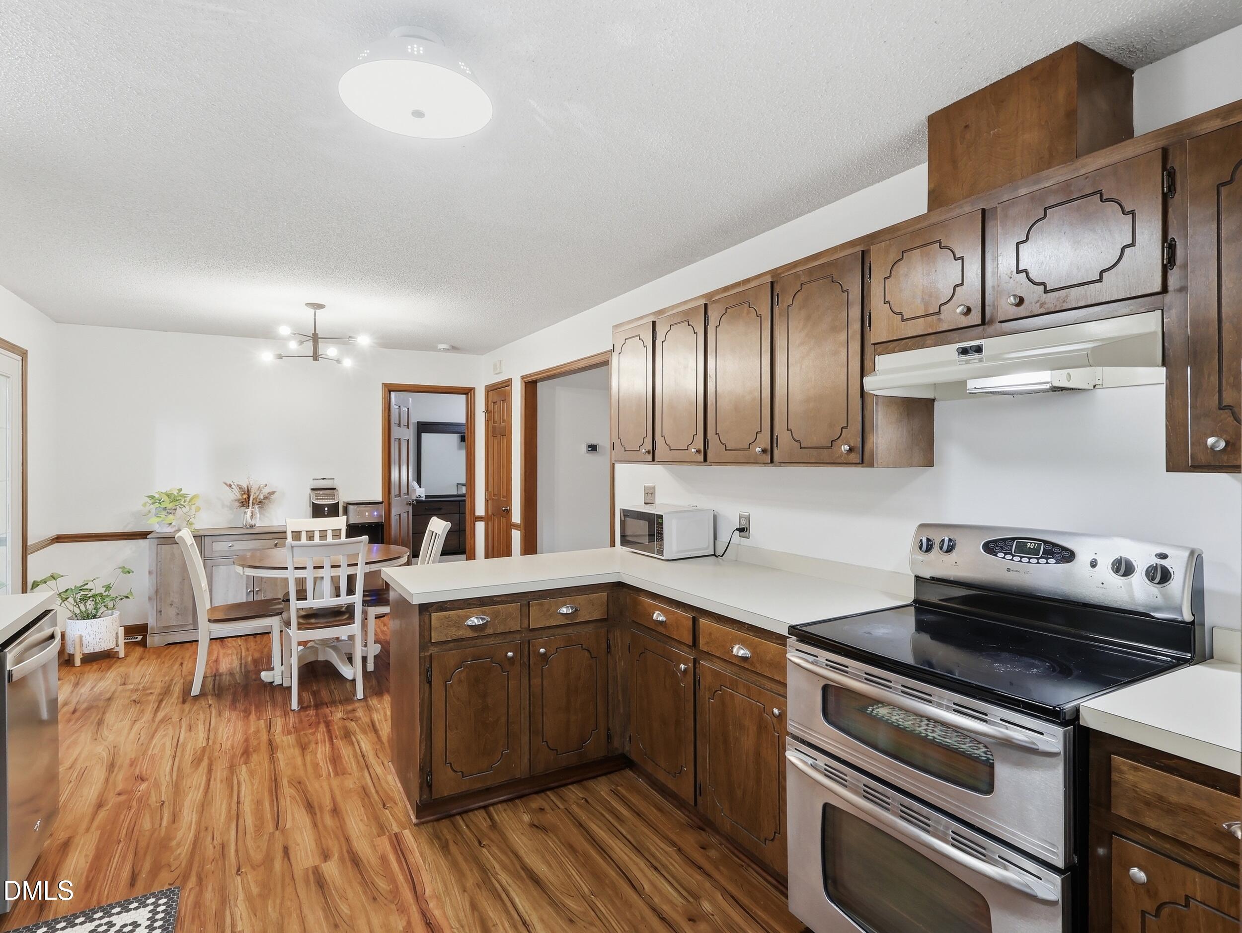 517 Lake Glad Road Wendell, NC 27591 - Photo 11 of 36 a kitchen with stainless steel appliances granite countertop a sink dishwasher stove and cabinets with wooden floor