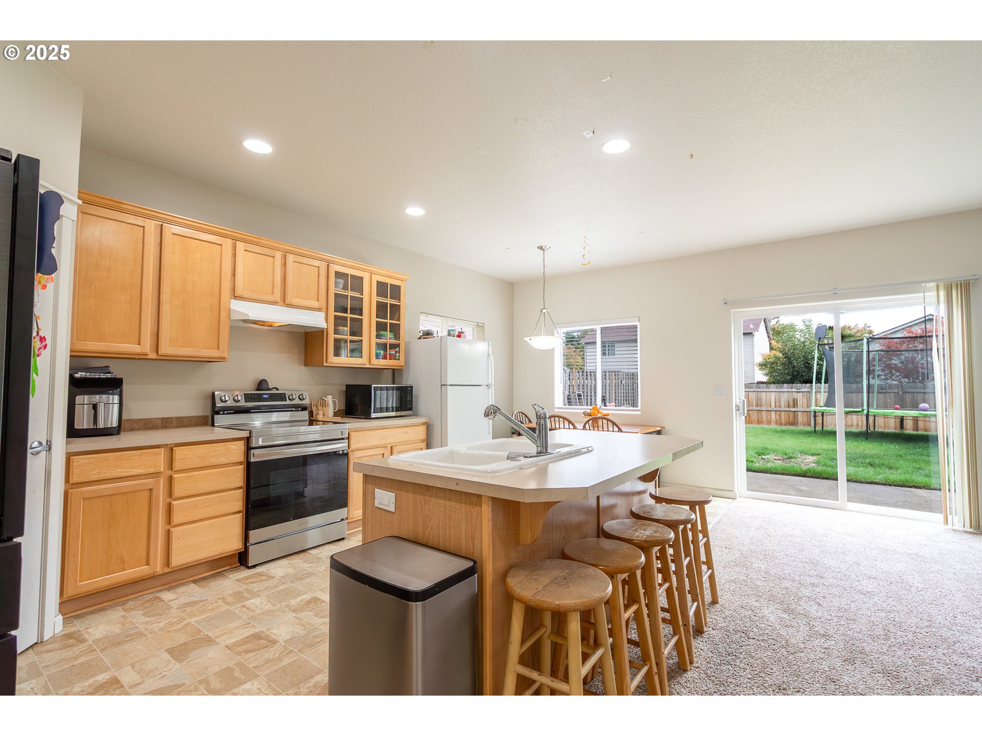 621 Jasmine Circle Independence, OR 97351 - Photo 13 of 29 a kitchen with a sink a stove a dining table and chairs