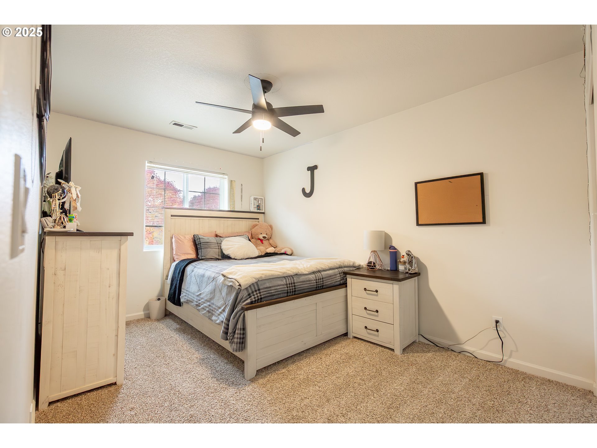 621 Jasmine Circle Independence, OR 97351 - Photo 25 of 29 a spacious bedroom with a bed and a chandelier