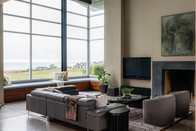 a living room with lots of furniture and a floor to ceiling window