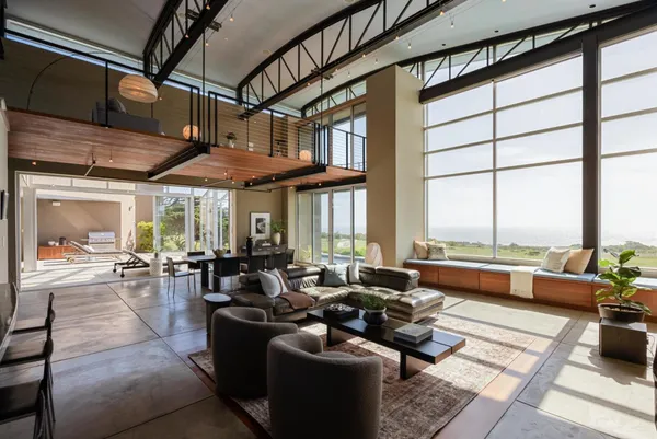 a living room with furniture and floor to ceiling window