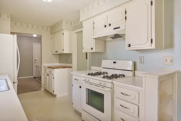 a kitchen with stainless steel appliances a white table and chairs