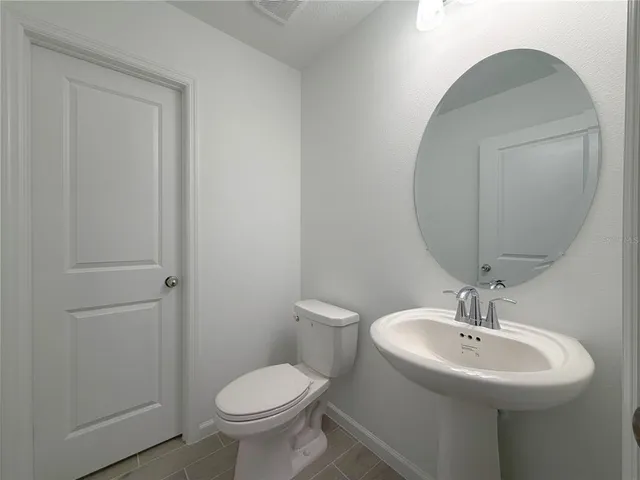 a bathroom with a sink toilet and a mirror