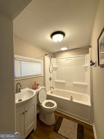 a bathroom with a granite countertop toilet a sink and a bathtub