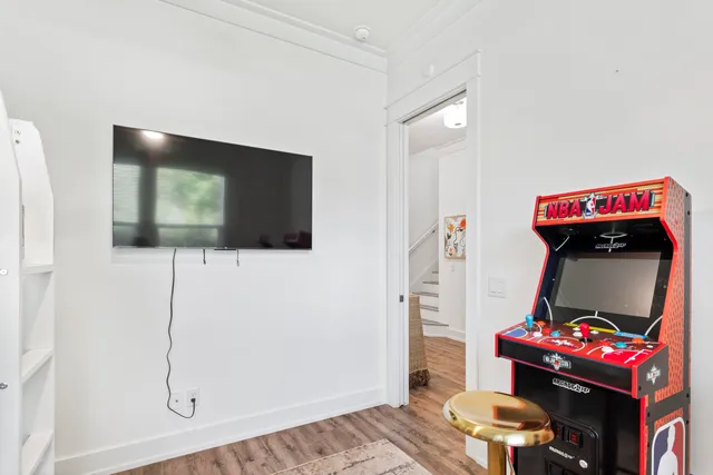 a living room with a bed furniture and a flat screen tv