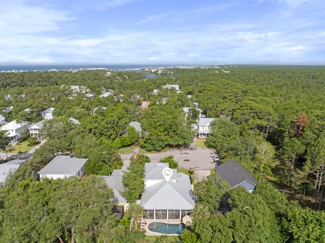 an aerial view of residential houses with outdoor space and trees