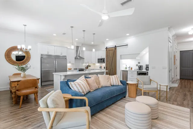 a living room with furniture a rug and kitchen view