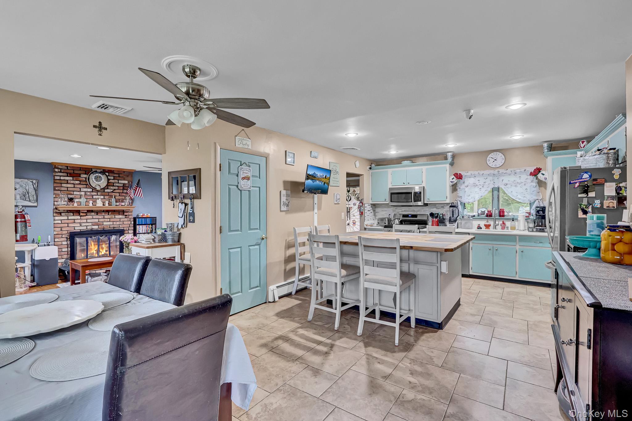 98 Granny Road Farmingville, NY 11738 - Photo 8 of 24 a kitchen with stainless steel appliances kitchen island granite countertop a table chairs and a refrigerator