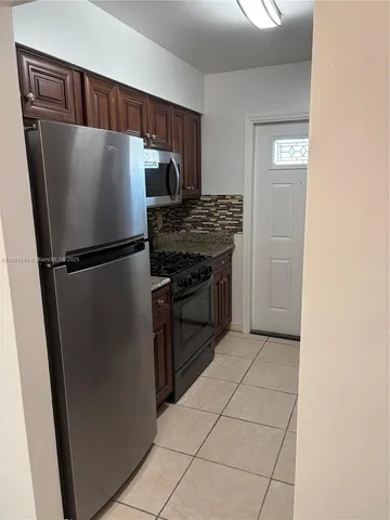 a kitchen with metallic refrigerator and a stove