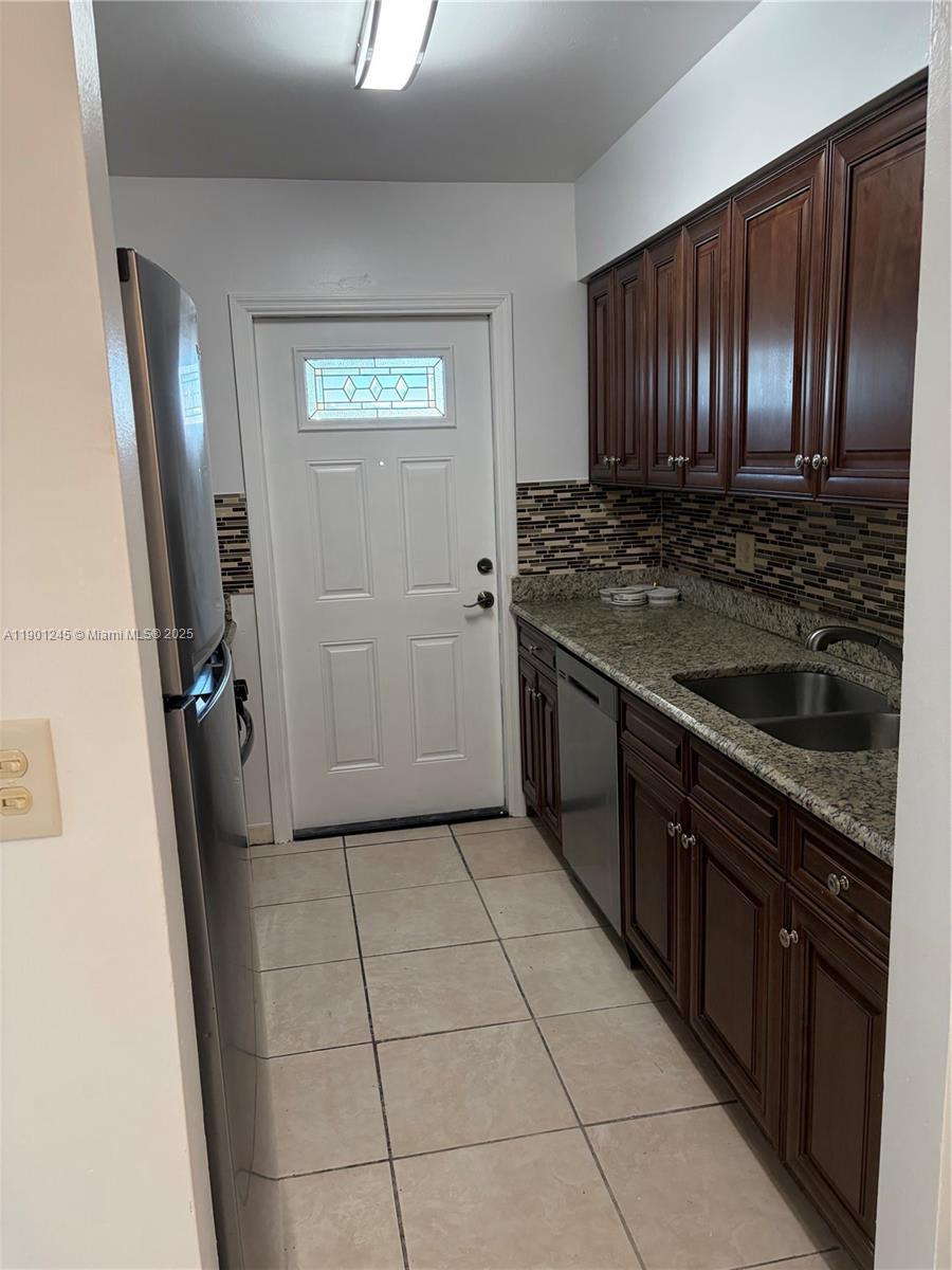 220 Southwest 7th Street, Unit 8 Boca Raton, FL 33432 - Photo 6 of 13 a kitchen with a stove a refrigerator and wooden cabinets