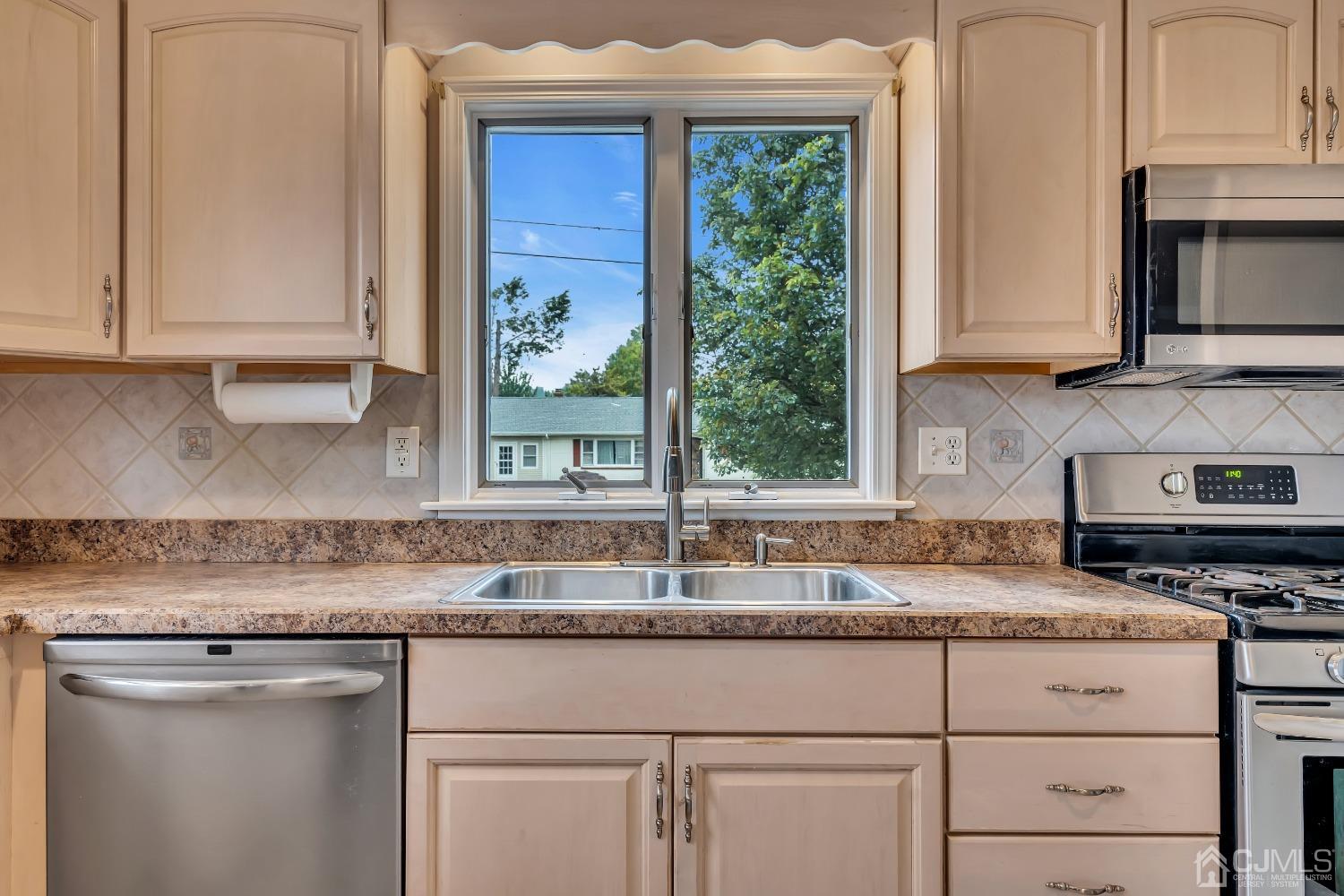 299 Fulton Street Middlesex, NJ 08846 - Photo 6 of 37 a kitchen with granite countertop white cabinets stainless steel appliances a window and a sink