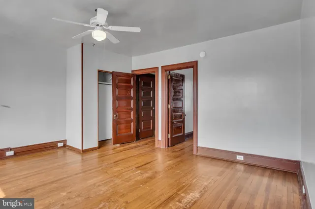 an empty room with wooden floor and closet