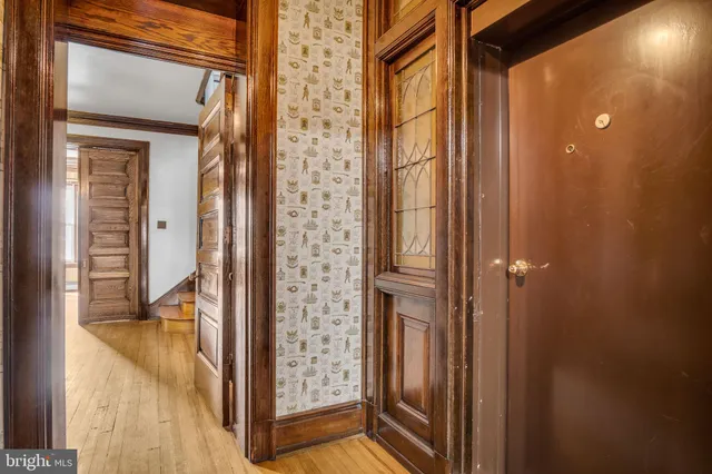 a view of an empty room with wooden floor fireplace and a window