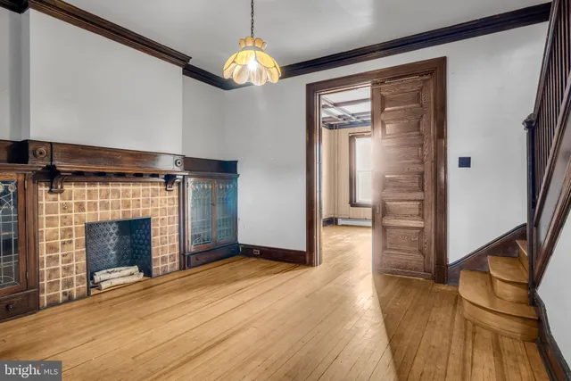 a view of empty room with wooden floor and fireplace