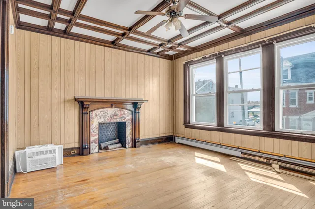 a view of an empty room with a fireplace and a window