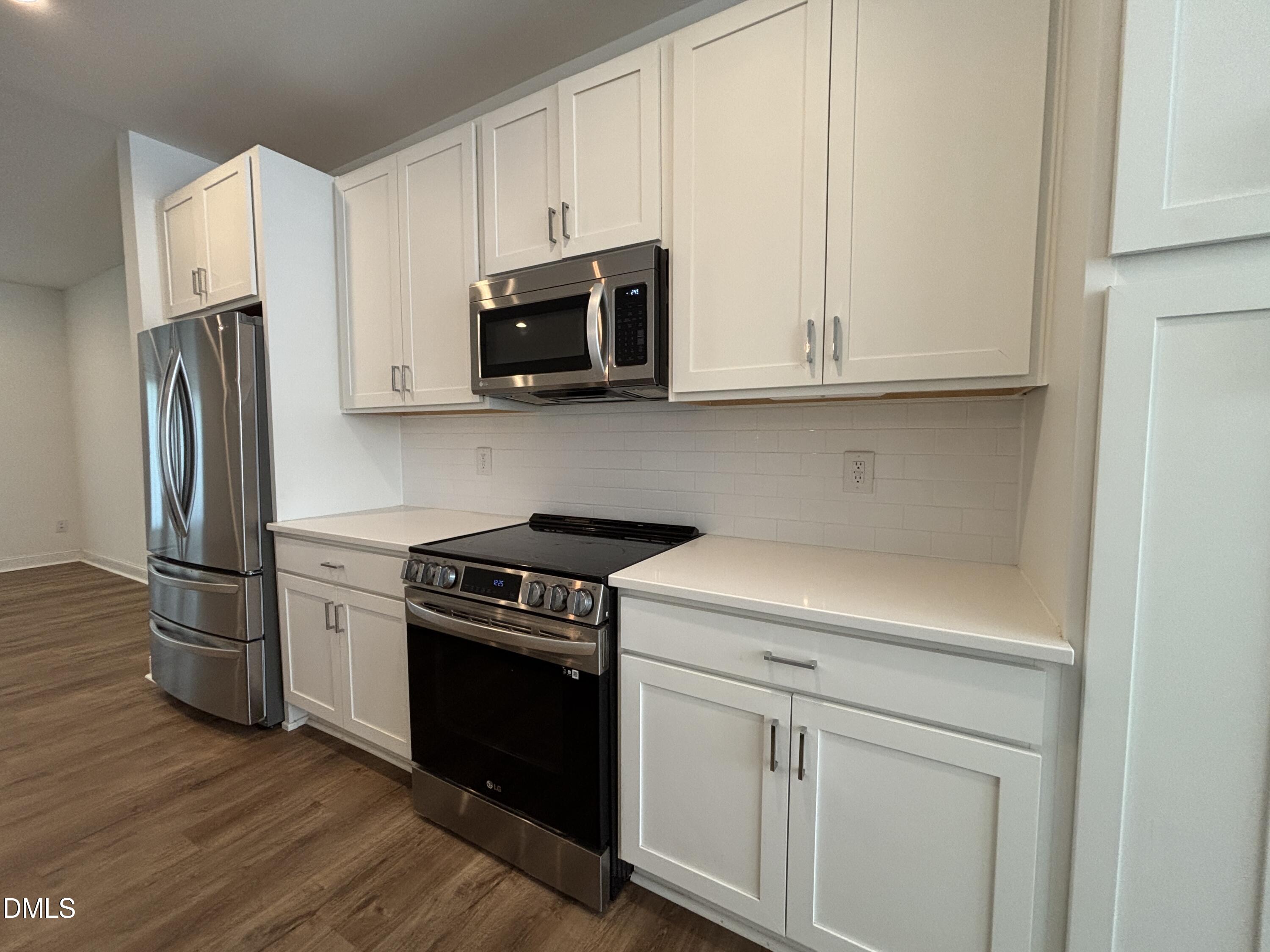 5710 Parker Pnes Court Raleigh, NC 27609 - Photo 17 of 78 a kitchen with white cabinets and stainless steel appliances