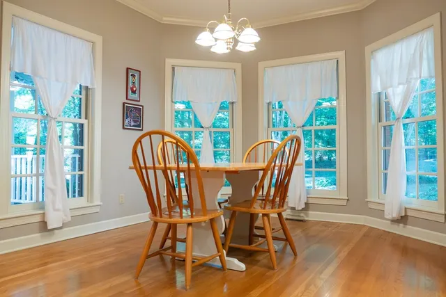 a view of a dining room with furniture a chandelier and wooden floor