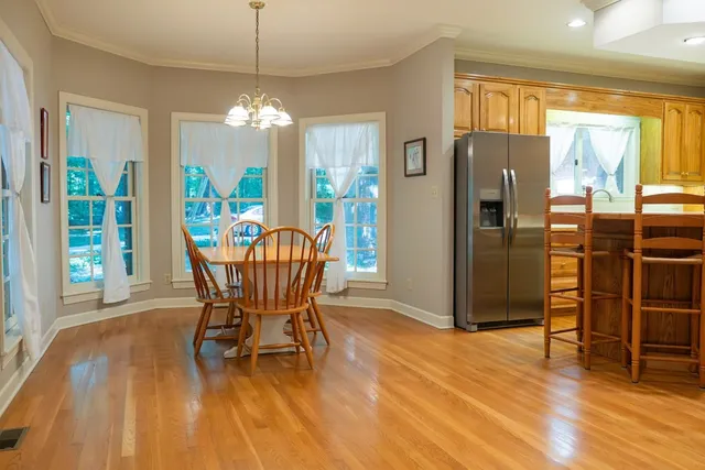 a dining room with furniture a chandelier and wooden floor
