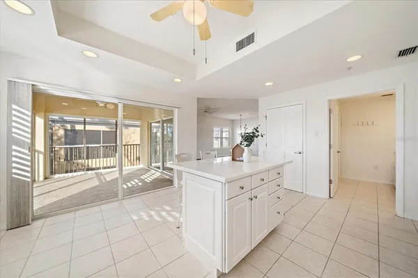 a large white kitchen with a large window a sink and a counter top space