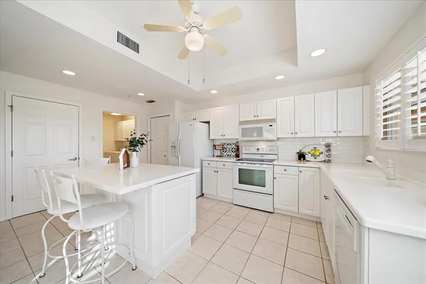 a kitchen with white cabinets and white appliances