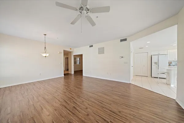 a view of an empty room with a window and wooden floor