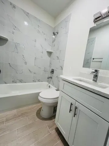 a bathroom with a toilet a sink a mirror and bathtub