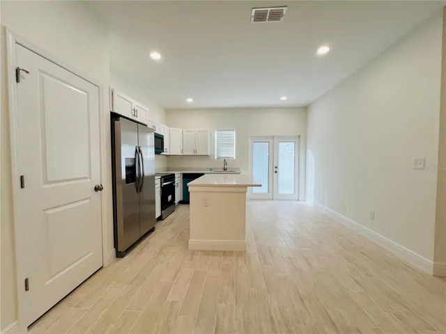 a view of kitchen with refrigerator stove microwave and cabinets