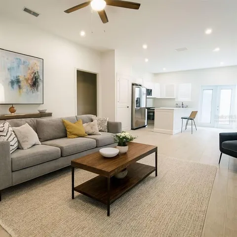 a living room with furniture and kitchen view