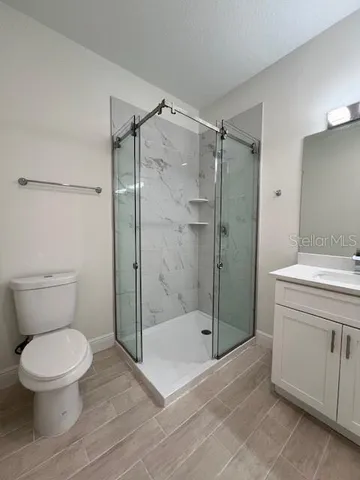 a bathroom with a shower a toilet and a sink