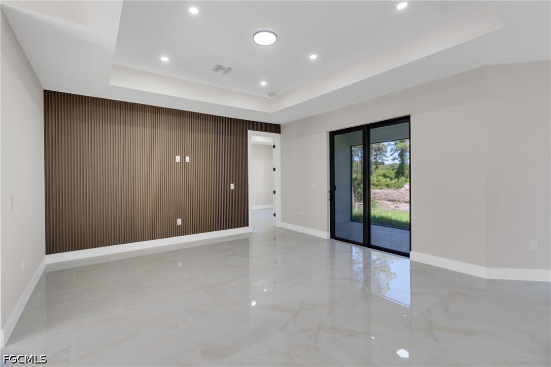 507 Trinity Street East Lehigh Acres, FL 33974 - Photo 17 of 50 wooden floor in an empty room with a window