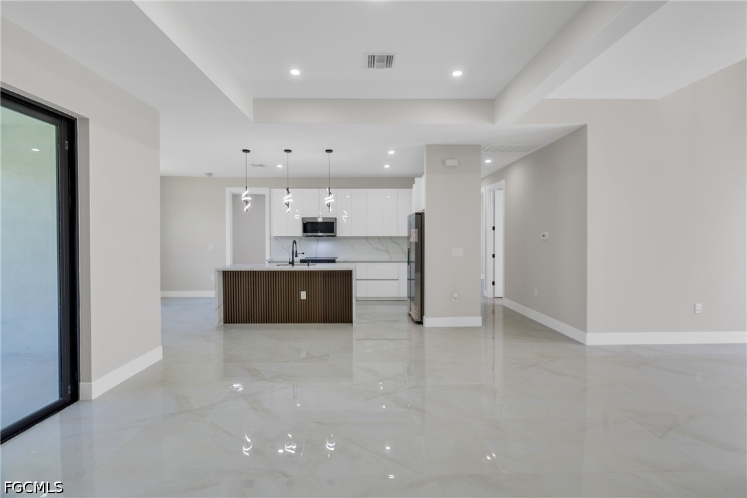 507 Trinity Street East Lehigh Acres, FL 33974 - Photo 19 of 50 a large white kitchen with a sink and a refrigerator