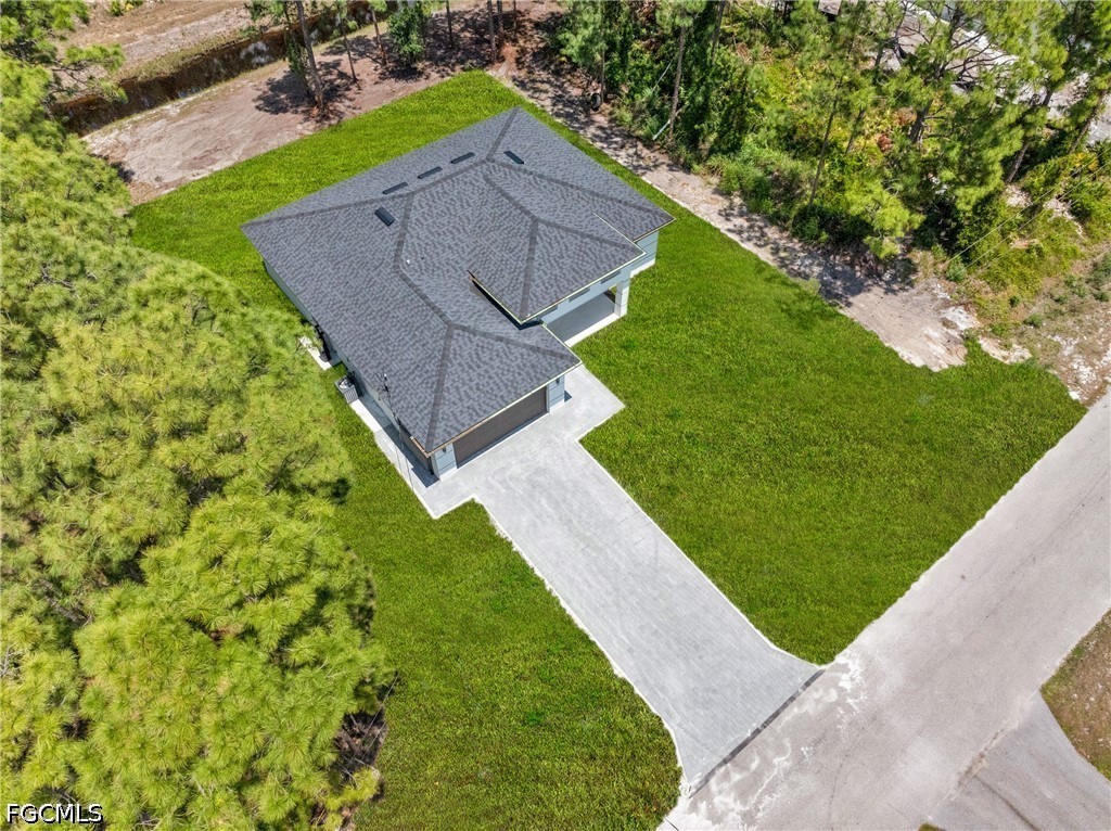507 Trinity Street East Lehigh Acres, FL 33974 - Photo 2 of 50 a view of a backyard with a garden and plants