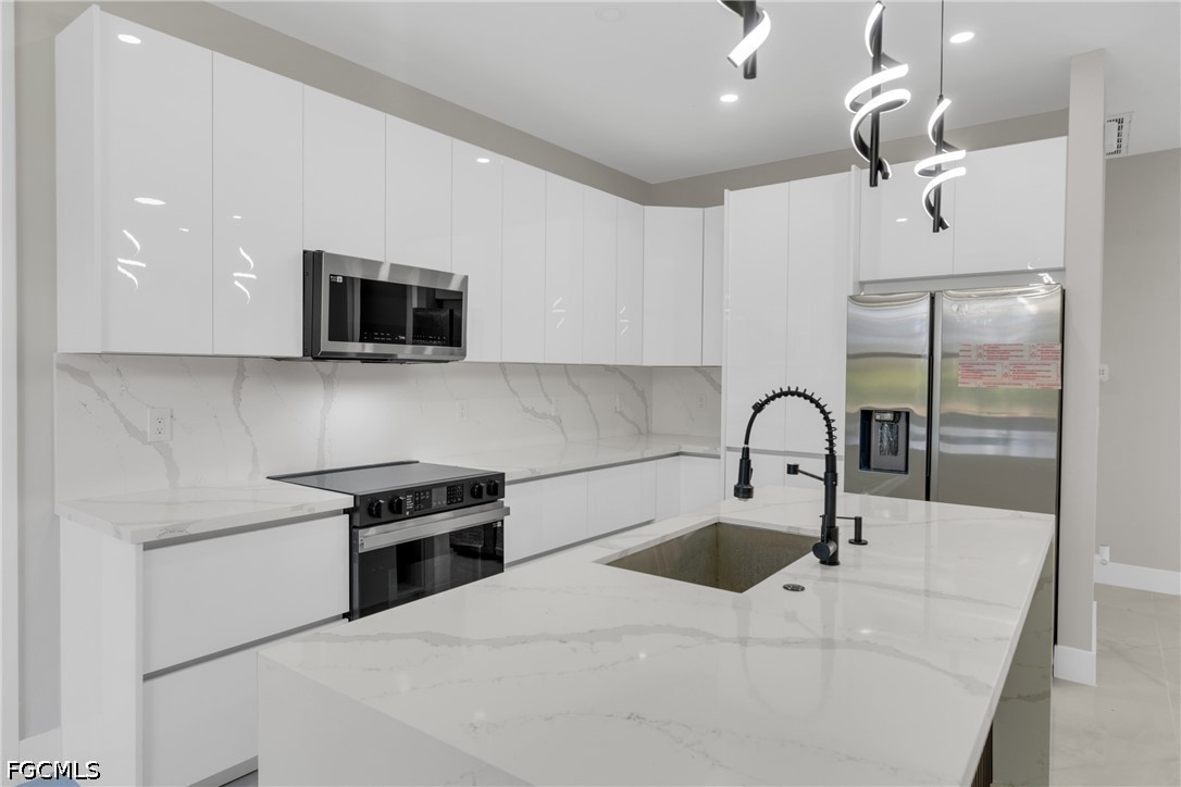 507 Trinity Street East Lehigh Acres, FL 33974 - Photo 22 of 50 a kitchen with a sink and a microwave