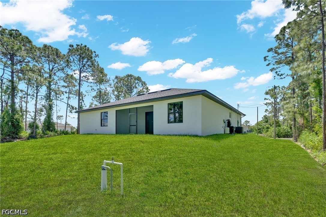 507 Trinity Street East Lehigh Acres, FL 33974 - Photo 45 of 50 a house that is sitting in the grass with large trees