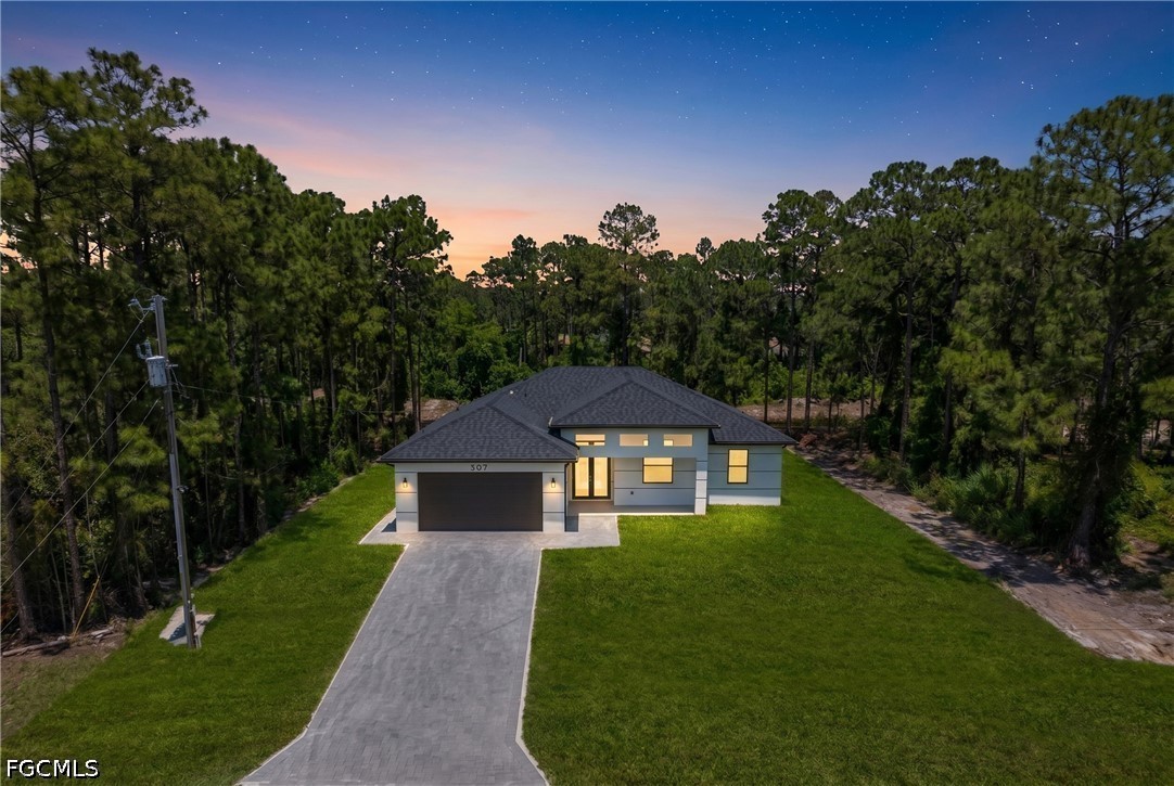 507 Trinity Street East Lehigh Acres, FL 33974 - Photo 5 of 50 a house with green field in front of it