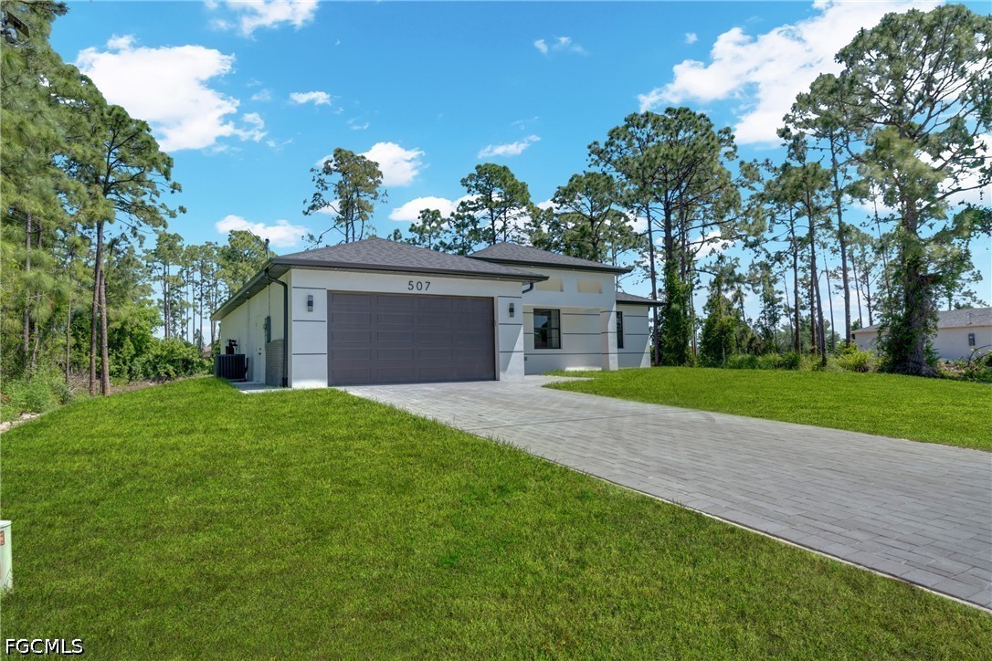 507 Trinity Street East Lehigh Acres, FL 33974 - Photo 6 of 50 a front view of a house with garden