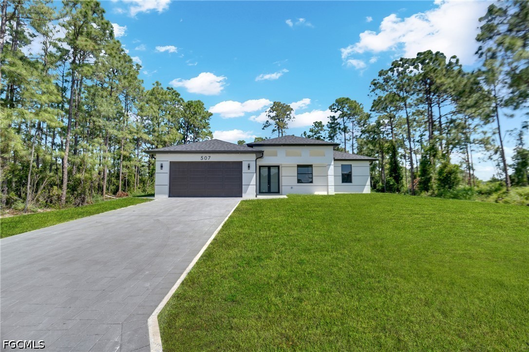 507 Trinity Street East Lehigh Acres, FL 33974 - Photo 7 of 50 a front view of house with a garden