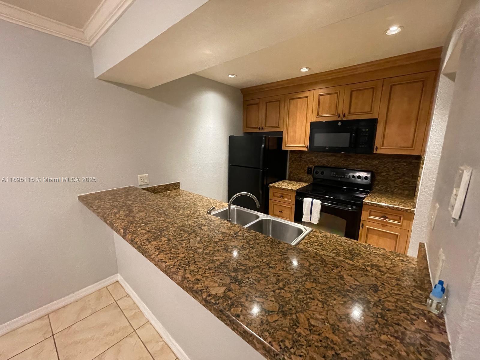 8100 Geneva Court, Unit 440 Doral, FL 33166 - Photo 2 of 11 a kitchen with stainless steel appliances granite countertop a sink stove and refrigerator