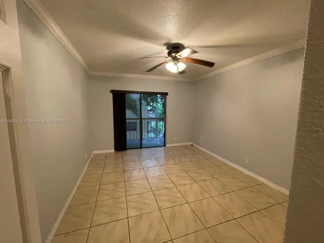 a view of an empty room with a chandelier fan