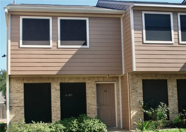 a front view of a house with plants