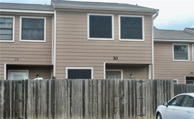 a view of a house with a car parked on the road