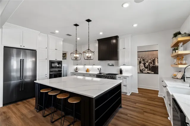 a kitchen with stainless steel appliances a stove microwave and a refrigerator
