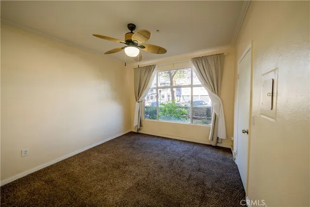 an empty room with a chandelier fan and closet