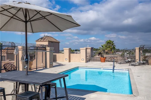 a swimming pool with outdoor seating and yard in the back