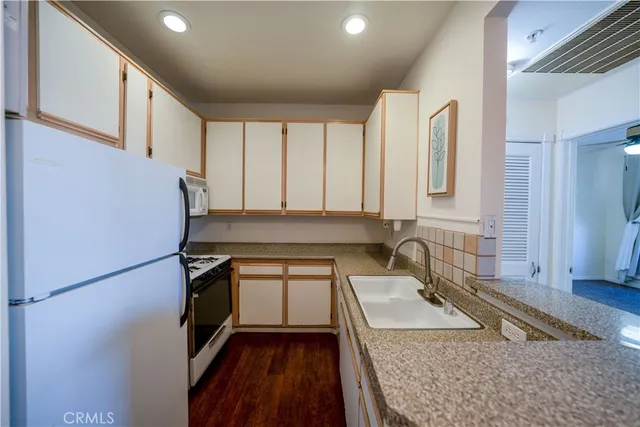 a kitchen with a refrigerator and a stove top oven