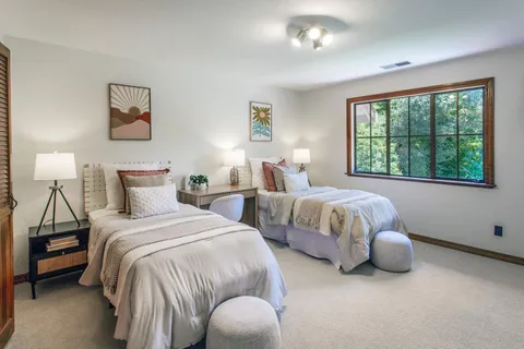 a bedroom with bed and a large window
