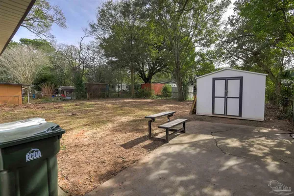 a view of a yard with a bench and trees